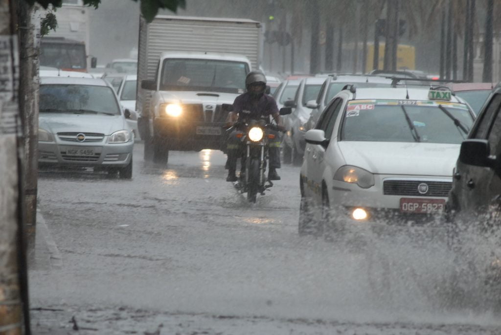 Carros e motos em rua alagada. | No comunicado, o Inmet informa a possibilidade de chuvas e ventos de até 100 km/h em todo estado de Goiás.