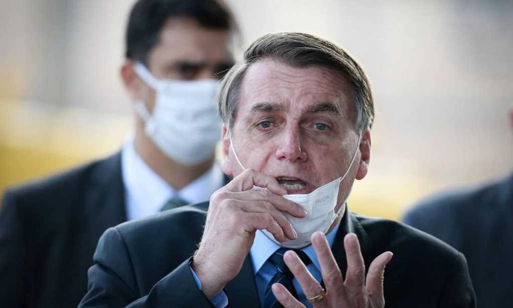 Bolsonaro com máscara no queixo, gesticulando.