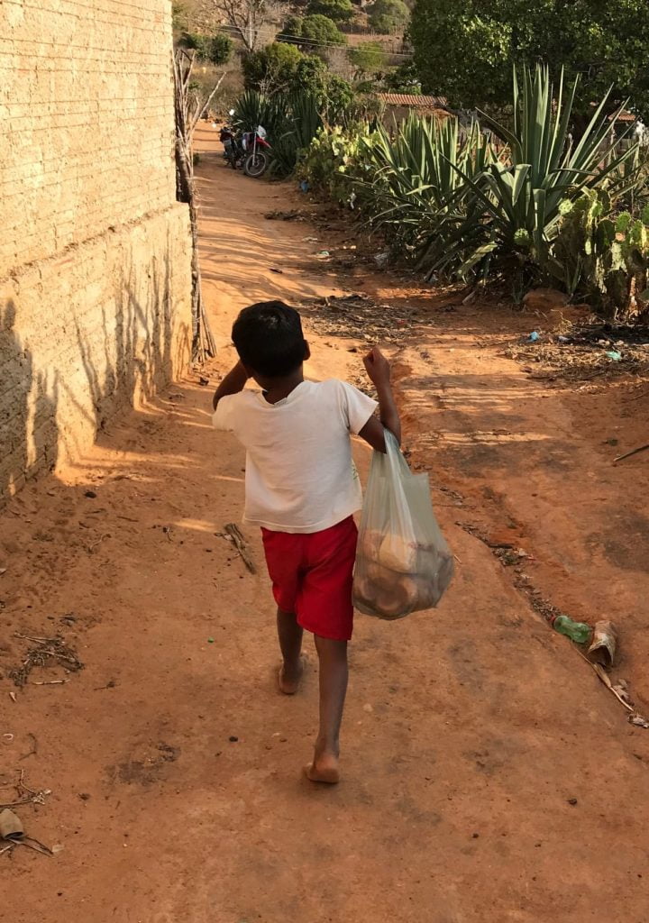 Criança carregando uma sacola. (Foto: Palloma Pire)