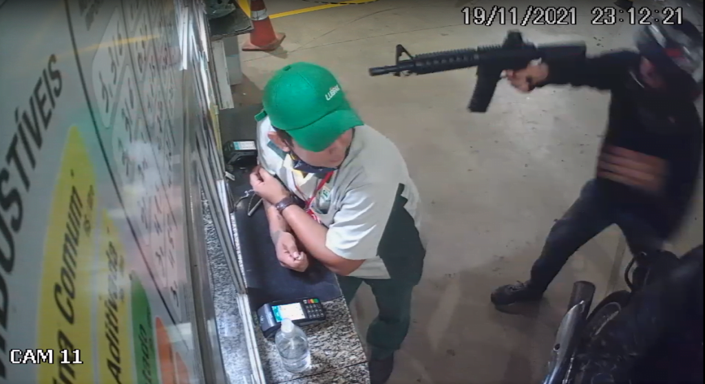 No vídeo, é possível acompanhar o momento em que dois homens encapuzados chegam com uma metralhadora e faz o roubo