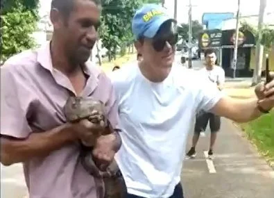 homem segura cobra em Goiânia