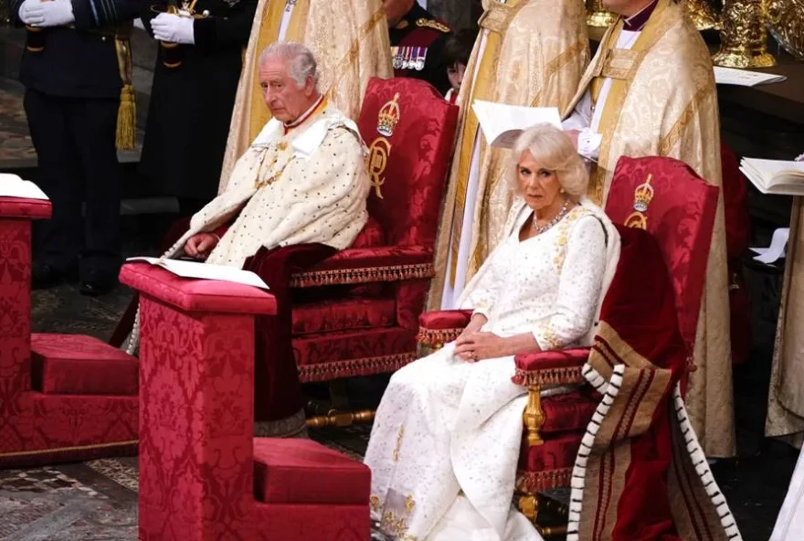 O rei Charles III e a rainha Camilla sentados nos Tronos de Estado. (Foto: Reprodução/Metrópoles)