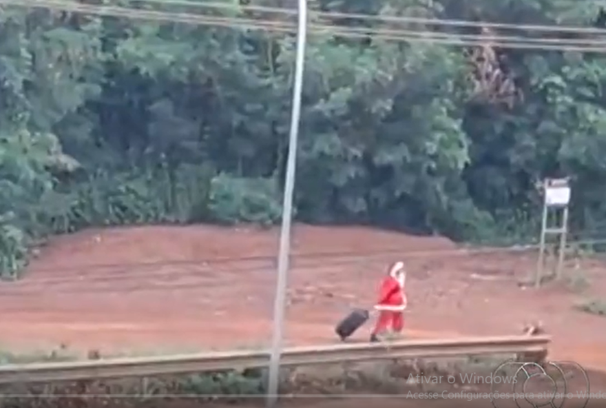 Papai Noel é visto andando em avenida com mala