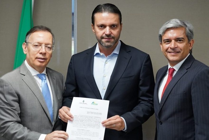 Presidente do TJGO, Carlos França, presidente da Agehab, Alexandre Baldy, e presidente da Comissão de Soluções Fundiárias, Anderson Máximo com Termo de Cooperação Técnica assinado 
(Foto: Reprodução/ Octacílio Queiroz)