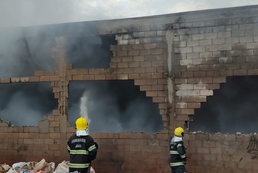 Dois bombeiros apagam chamas em galpão de materiais reclicáveis. | Segundo bombeiros, as equipes se concentraram em combater o foco de incêndio, devido a presença de materiais inflamáveis.