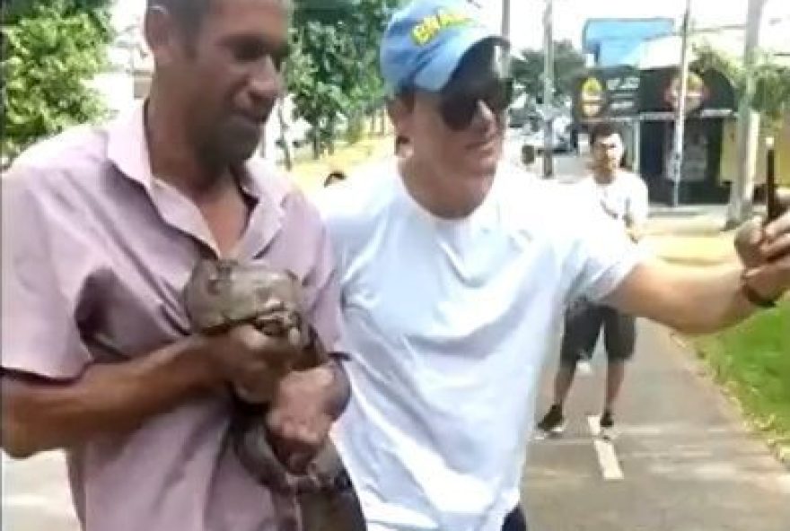 homem segura cobra em Goiânia