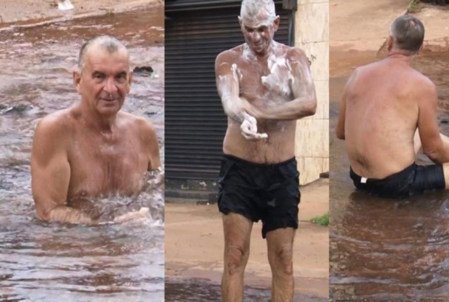 Homem tomando banho em burado de avenida (Reprodução/Redes Sociais)