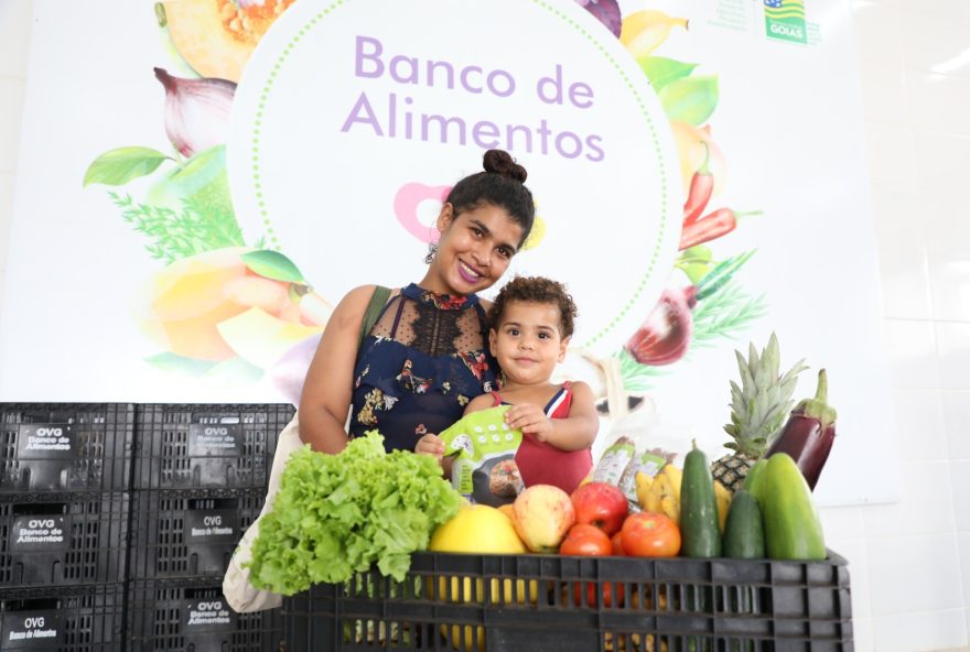 Com pacotes do Mix do Bem em mãos e entre frutas, legumes e verduras in natura, Joice Fernanda Ferreira de Oliveira, 27 anos, comemora os benefícios recebidos do Goiás Social
(Fotos: Aline Cabral)