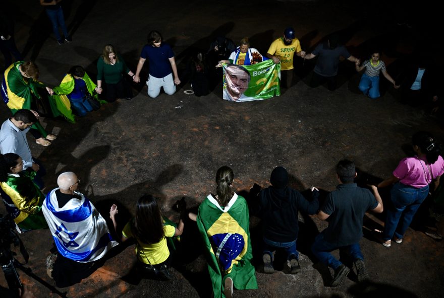 Supporters of former Brazilian President Jair Bolsonaro pray during a vigil near the former president's home in Brasilia on September 1, 2025. The former army captain is accused of conspiring to stay in power after his electoral defeat to leftist President Luiz Inacio Lula da Silva in 2022. A conviction in court -- with a verdict due any time from September 2-- could send the 70-year-old to prison, perhaps for the rest of his life. (Photo by Evaristo Sa / AFP)