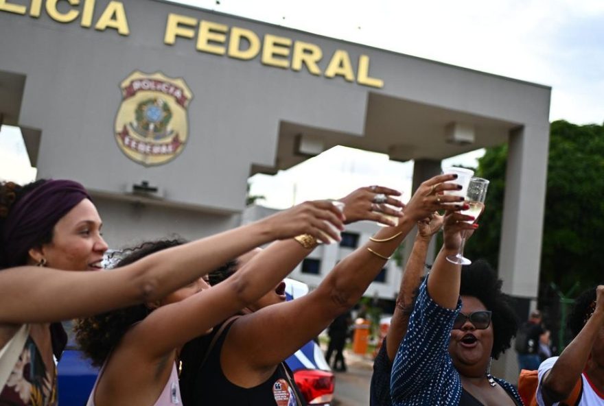AME2569. BRASILIA (BRASIL), 25/11/2025.- Personas celebran frente de la Superintendencia de la Policía Federal donde el expresidente de Brasil Jair Bolsonaro se encuentra preso este martes, en Brasilia (Brasil). Bolsonaro comenzó a cumplir la condena a 27 años de prisión que le fue impuesta por intento de golpe de Estado en una pequeña sala de doce metros cuadrados de la sede de la Policía Federal en Brasilia. EFE/ Andre Borges