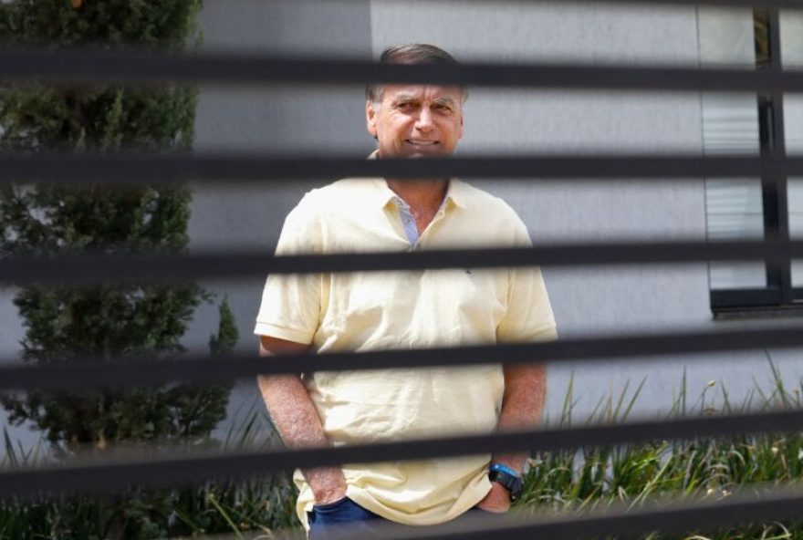 (FILES) Former Brazilian President Jair Bolsonaro gestures from his residence in Brasilia on September 3, 2025. Brazil's far-right former president Jair Bolsonaro is running out of options to avoid prison, with judges on November 14, 2025 set to reject his appeal against a 27-year sentence for a botched coup bid. (Photo by Sergio Lima / AFP)