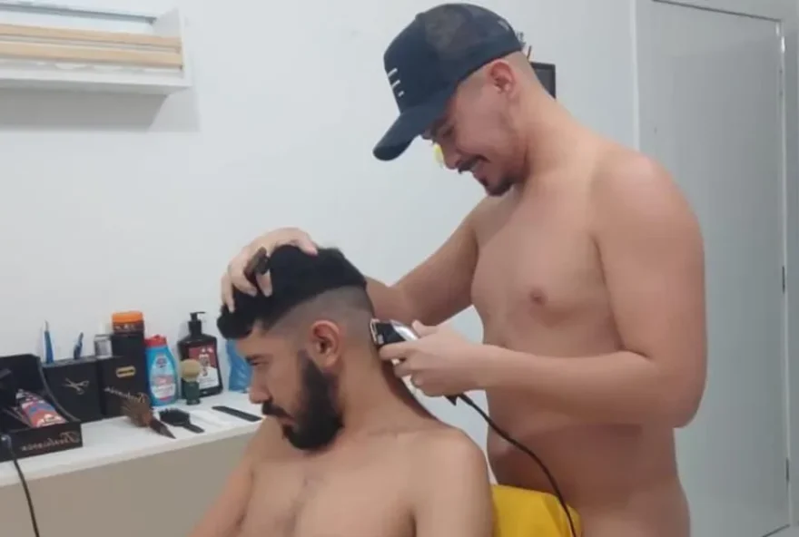 Empresário cortando o cabelo de cliente nu. (Foto: Reprodução/g1)