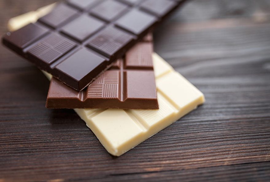 Delicious and sweet chocolate bars on wooden background