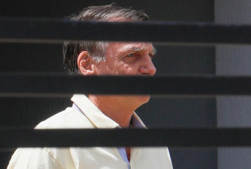 Former Brazilian President Jair Bolsonaro gestures from his residence in Brasilia on September 3, 2025. Brazil's Supreme Court on Tuesday began verdict deliberations in the trial of former president Jair Bolsonaro, who is accused of plotting a coup to attempt to retain power after he lost the 2022 election. (Photo by Sergio Lima / AFP)
