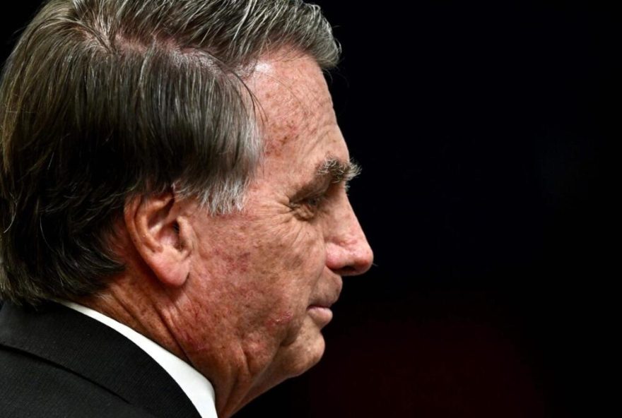 (FILES) Former Brazilian President Jair Bolsonaro gestures during a session of the Brazilian Supreme Court judging the participation of those accused of the attempted coup d'état in January 2023, in Brasilia on June 9, 2025. Former Brazilian President Jair Bolsonaro, who was hospitalized with bronchopneumonia, was released from intensive care on March 23, 2026, one of his doctors reported, as he awaits the Supreme Court’s decision on whether to grant him house arrest. (Photo by EVARISTO SA / AFP)