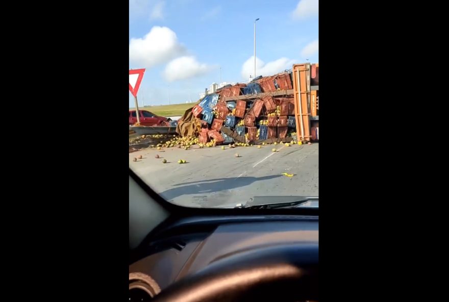 Caminhão carregado de limões tombou na alça de acesso à GO-020, causando lentidão no trânsito (Foto: reprodução de vídeo)