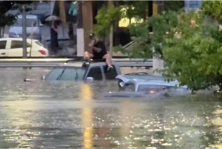 caos-em-sao-paulo3A-homem-sobe-no-carro-para-escapar-de-alagamento