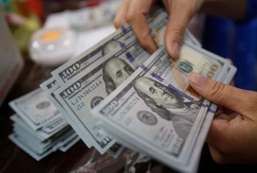 FILE PHOTO: An employee of a bank counts US dollar notes at a branch in Hanoi, Vietnam May 16, 2016. REUTERS/Kham