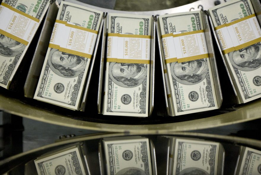 Stacks of one hundred dollar bills pass through a circulator machine at the Bureau of Engraving and Printing in Washington, D.C., US. Photographer: Andrew Harrer/Bloomberg