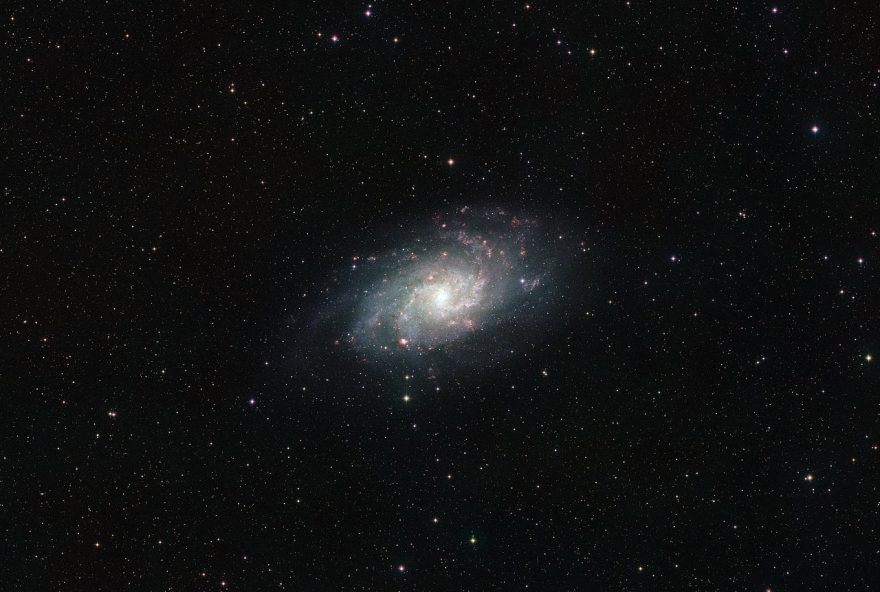 This wide field view of the sky around the nearby galaxy Messier 33 was assembled from images forming part of the Digitized Sky Survey 2. The original photographs were taken over a period spanning more than 40 years, from 1949 until the early 1990s. As a result some of the nearer stars in the picture have moved due to their significant proper motions. These show up as double dots — one red and one blue. The huge galaxy at the centre of the picture is tens or hundreds of thousands of times more distant than these nearby stars.