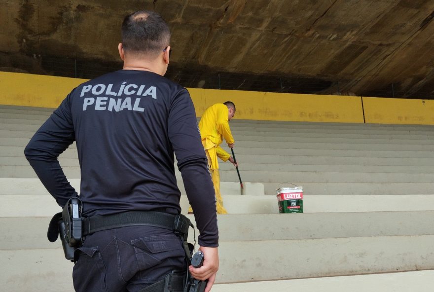 Reeducandos trabalham na pintura da arquibancada do Serra Dourada, em Goiânia, sob vigilância policial