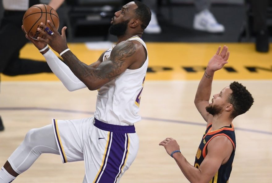 LeBron James, do Los Angeles Lakers, faz pontos sobre Stephen Curry, do Golden State Warriors, no Staples Center — Foto: Harry How/Getty Images