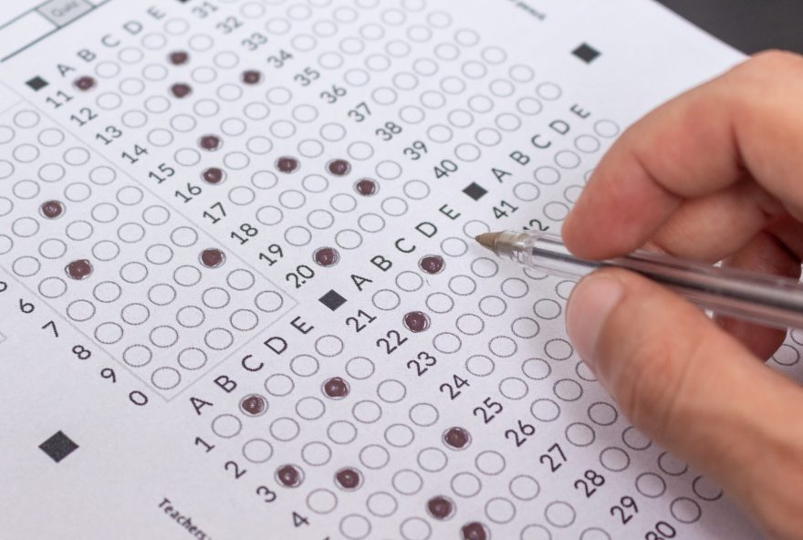 Person,Filling,Out,An,Exam,Answer,Sheet,With,A,Pen,