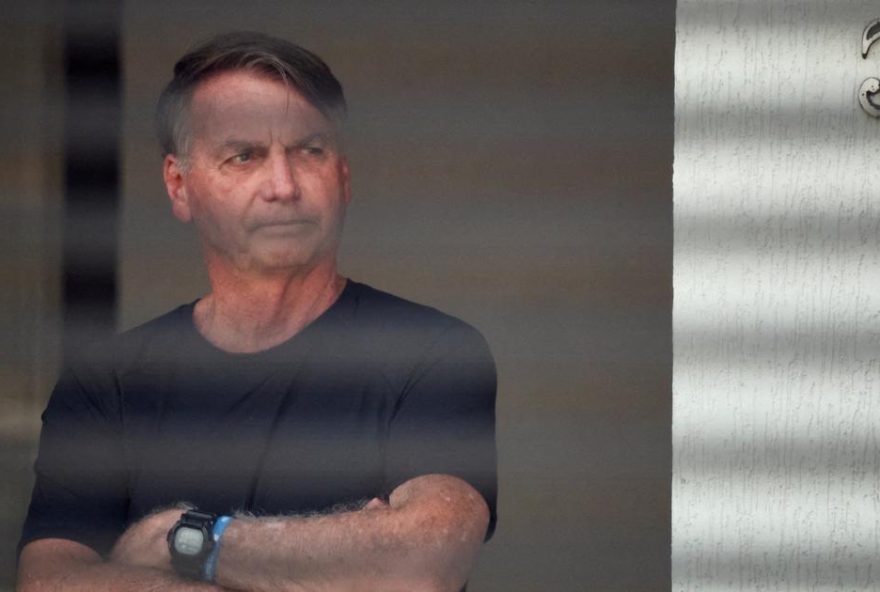 FILE PHOTO: Brazil's former President Jair Bolsonaro stands at his home while under house arrest, ordered by Supreme Court Justice Alexandre de Moraes, as he awaits trial over an alleged plot to overturn the 2022 election, in Bras?lia, Brazil, August 14, 2025. REUTERS/Adriano Machado/File Photo