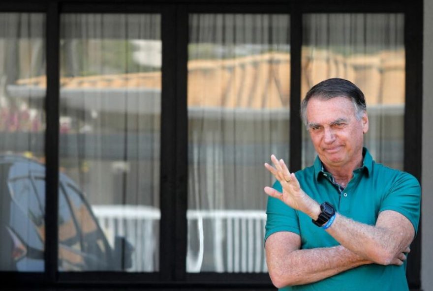 Former Brazilian President Jair Bolsonaro waves at his residence in Brasilia on September 11, 2025. A Brazilian judge on September 10 returned the first not-guilty vote in the coup-plotting trial of former president Jair Bolsonaro, shifting all eyes on the last two of his colleagues left to vote following two guilty findings. The 70-year-old far-right ex-leader risks a prison sentence of more than 40 years if found guilty of seeking to claw back power after his defeat in 2022 elections to leftist Luiz Inacio Lula da Silva (Photo by Sergio Lima / AFP)