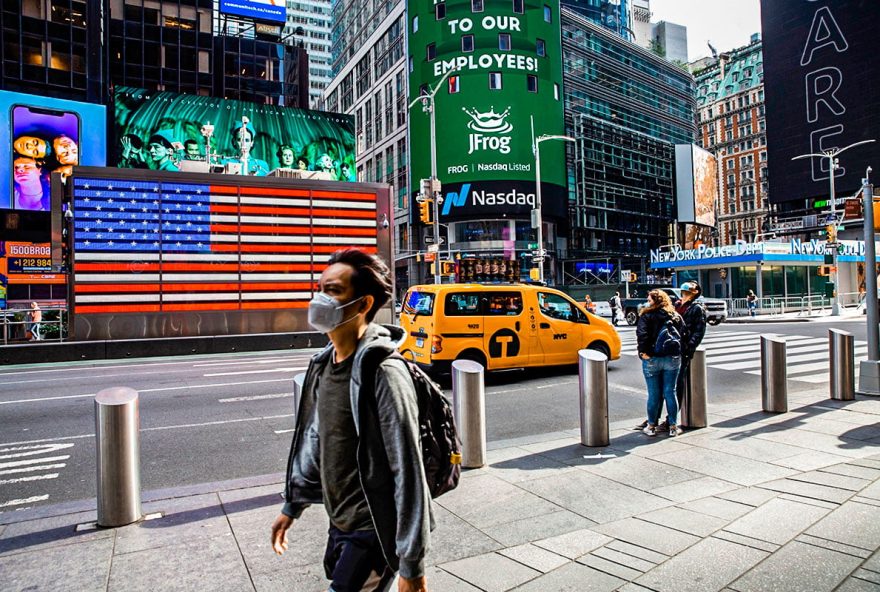 Pedestrians wearing protective masks walk past the Nasdaq MarketSite in New York, U.S., on Friday, Oct. 2, 2020. New York faced pressure as middle and high schools reopened, infection rates in virus hot spots rose further and the city's bond rating was cut by Moody's. Photographer: Michael Nagle/Bloomberg