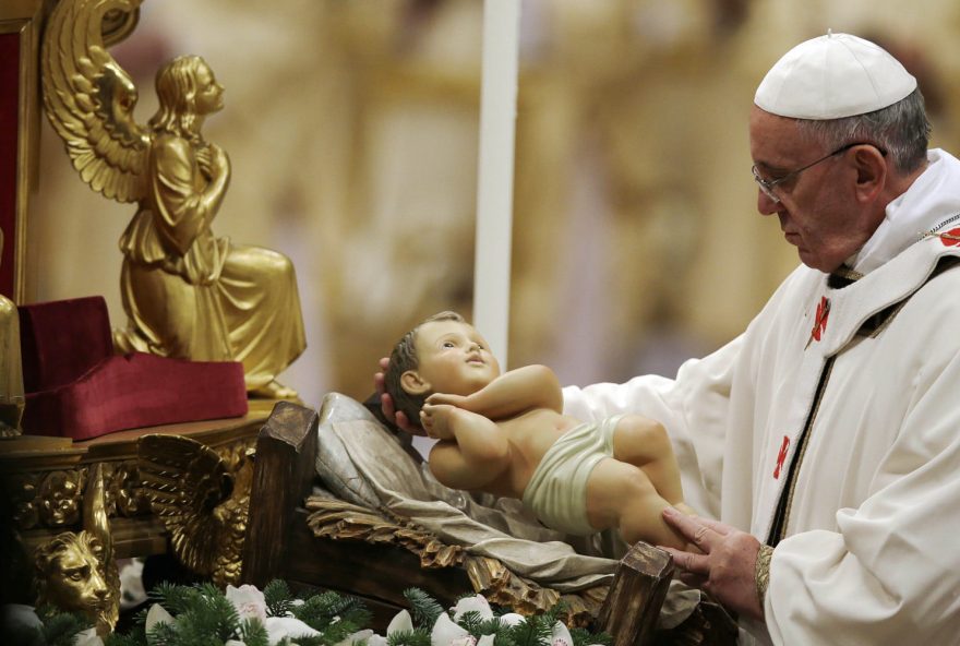 Pope Francis holds a statue of baby Jesus as he celebrates the Christmas Eve Mass in St. Peter's Basilica at the Vatican, Tuesday, Dec. 24, 2013. (AP Photo/Gregorio Borgia)