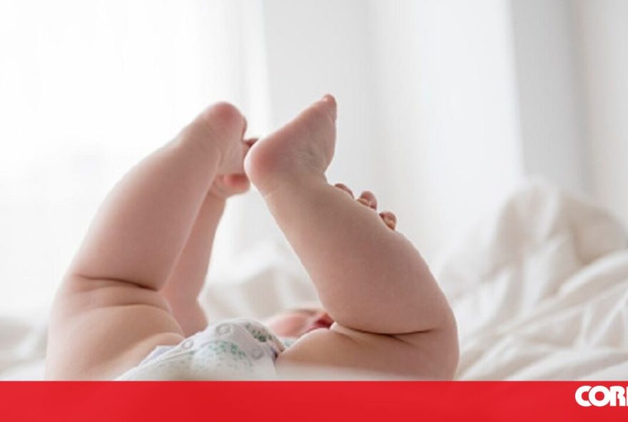 Baby girl (12-17 months) lying down with legs up