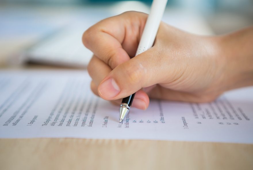 Close up of hand completing an employment application form Close up of hand completing an employment application form