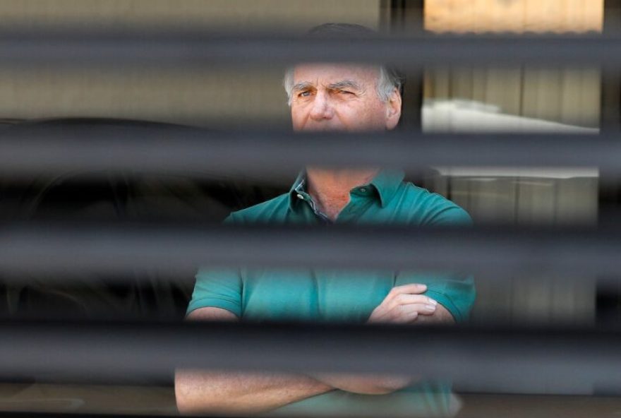 Former Brazilian President Jair Bolsonaro stands at the garage of his residence in Brasilia on September 11, 2025. A Brazilian judge on September 10 returned the first not-guilty vote in the coup-plotting trial of former president Jair Bolsonaro, shifting all eyes on the last two of his colleagues left to vote following two guilty findings. The 70-year-old far-right ex-leader risks a prison sentence of more than 40 years if found guilty of seeking to claw back power after his defeat in 2022 elections to leftist Luiz Inacio Lula da Silva (Photo by Sergio Lima / AFP)