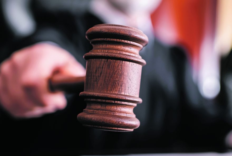 selective focus of wooden gavel in hand of blurred judge in court selective focus of wooden gavel in hand of blurred judge in court