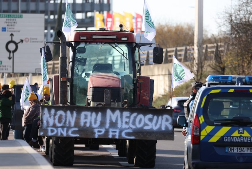 A tractor blocks the traffic during a farmers protest against the Mercosur trade deal with South American nations and other issues Thursday, Dec. 18, 2025 in Portet-sur-Garonne, southwestern France. (AP Photo/Fred Scheiber)