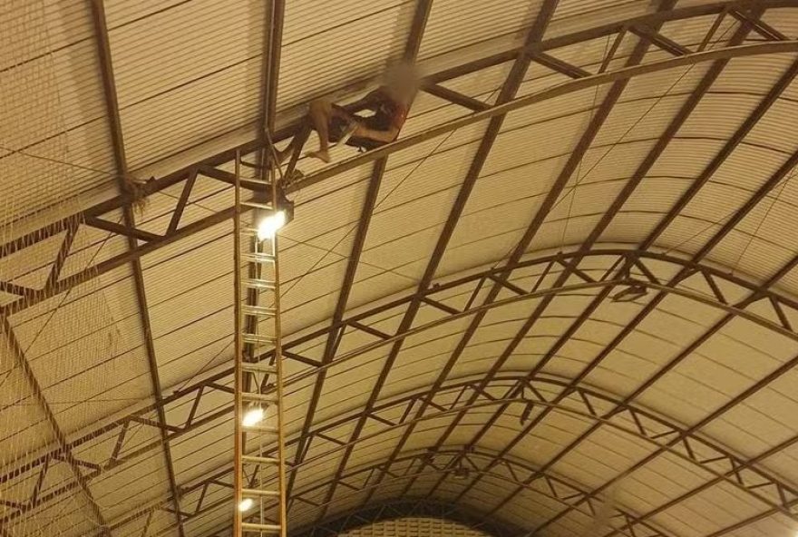 Jovem estava jogando futebol com amigos quando o equipamento ficou preso e decidiu subir até a estrutura de ferro. Ele foi resgatado sem ferimentos. (Foto: Corpo de Bombeiros)