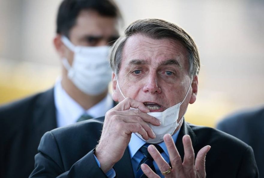 Bolsonaro com máscara no queixo, gesticulando.